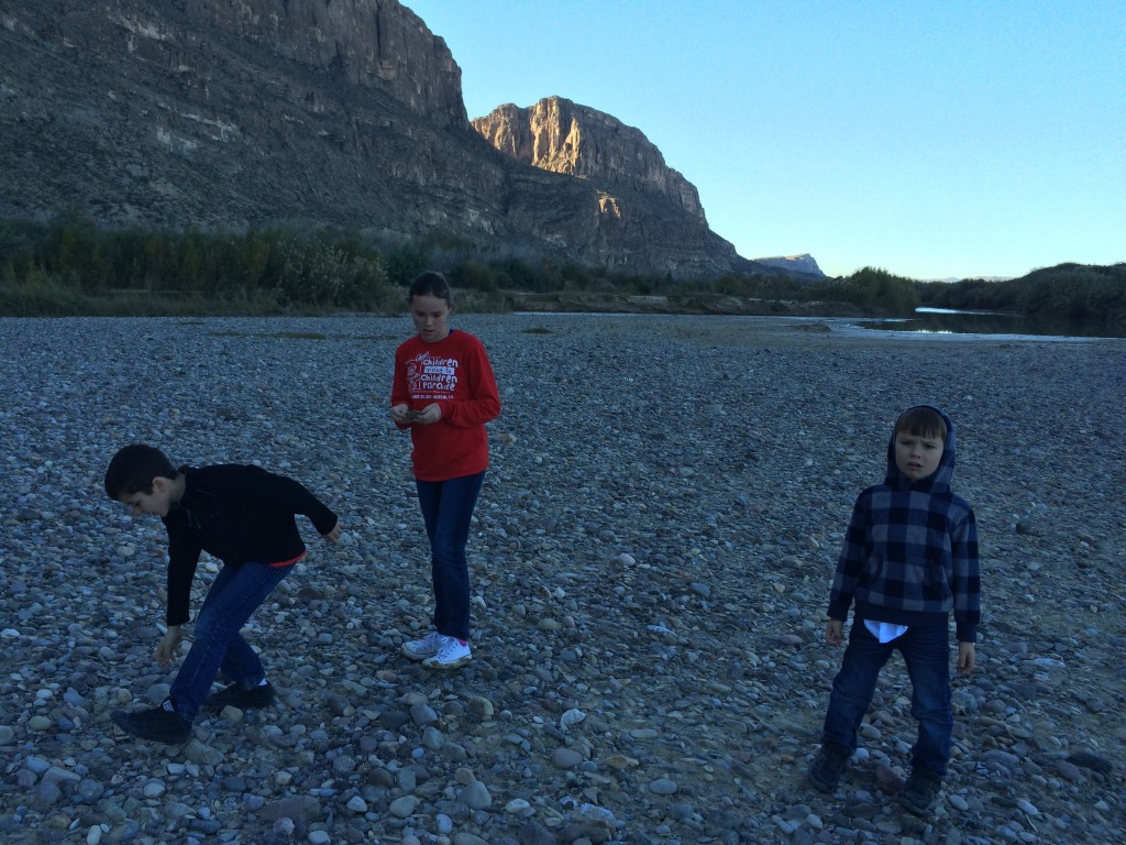 The carful of kids look for the perfect rock to skip along the Rio Grande in Santa Elena Canyon. Big Bend National Park for kids,